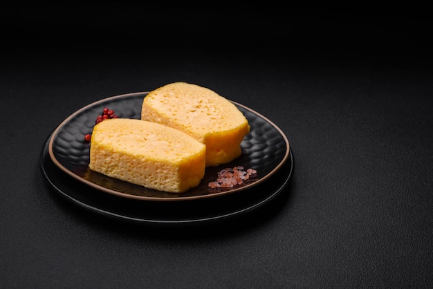 Delicious porous yellow cheese cut in large pieces on a ceramic plate