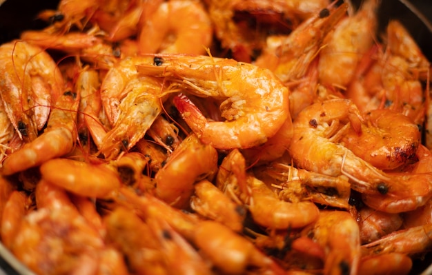 Delicious prepared shrimps in the fry pan. Roasted shrimps with herbs. Seafood, shellfish. Shrimps Prawns grilled with spices on cast iron pan. Close up photo