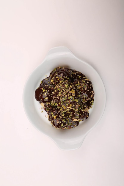 Delicious profiteroles with chocolate on the table