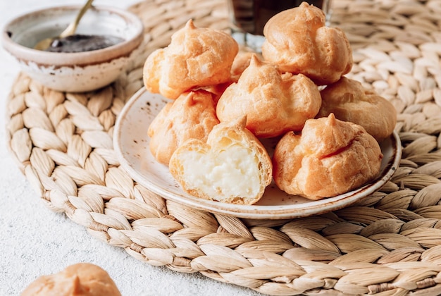 Delicious profiteroles with coffee on the table Image with selective focus