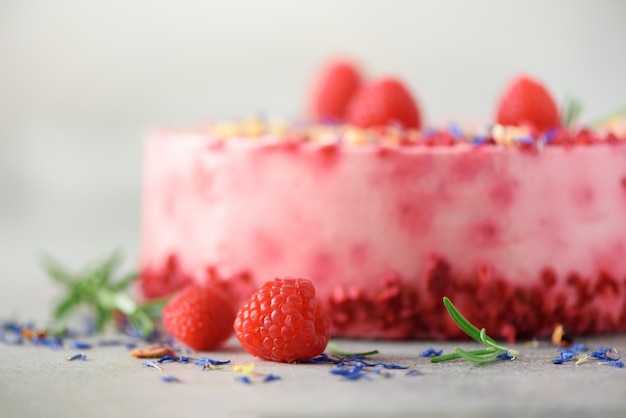 Delicious raspberry cake with fresh berries, rosemary and dry flowers. Copy space for your text. Vegetarian, vegan food concept