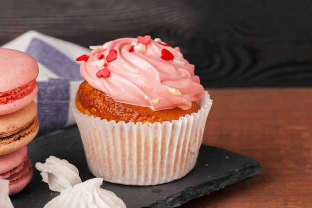 Delicious raspberry and caramel cupcakes on dark background