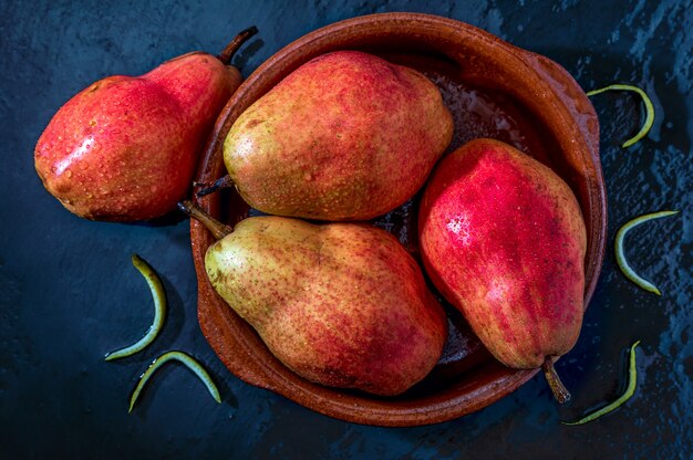 Delicious red pears in clay pot.