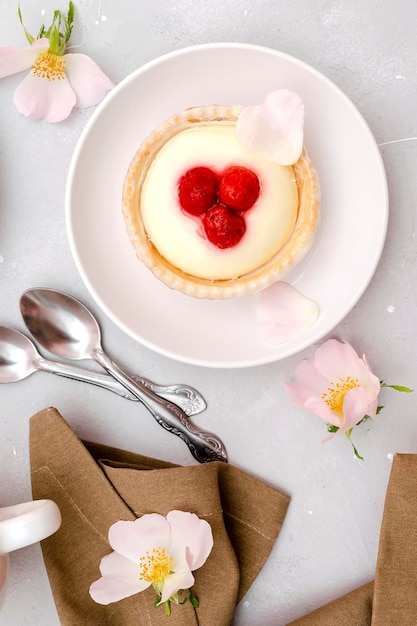 Delicious red raspberry strawberry whipped creamy tartletscakesgourmet confection dessert on plate with latte coffeemilksweet tasty pastry baked pie cheesecake with ripe berries on gray table