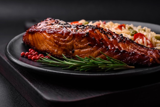 Delicious red salmon fish grilled with sauce and sesame seeds with rice and vegetables