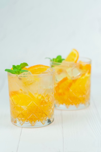 Delicious refreshing cocktail drink with alcohol and orange with mint leaf