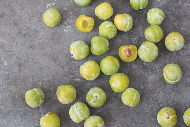 Delicious ripe green plums Greengages Black textured concrete background 