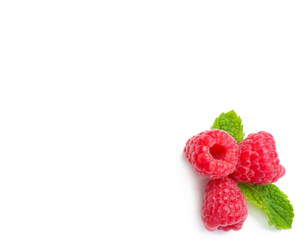 Delicious ripe raspberries with mint on white surface