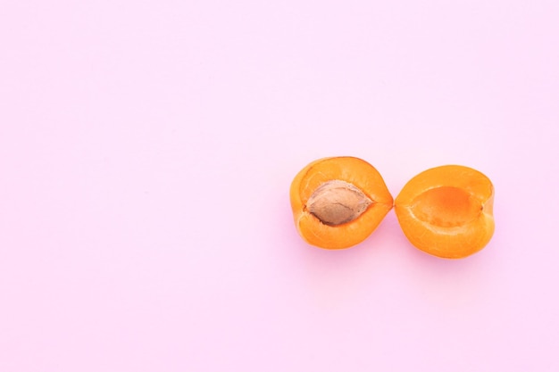 Delicious ripe sweet apricots on pink background flat lay