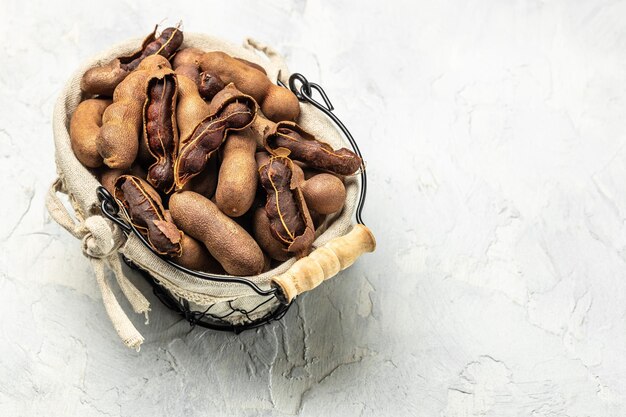 Delicious ripe tamarinds on a basket on a light background Long banner format top view