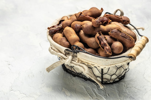 Delicious ripe tamarinds on a basket on a light background Long banner format top view