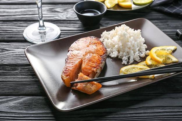 Delicious roasted salmon steak with rice on plate