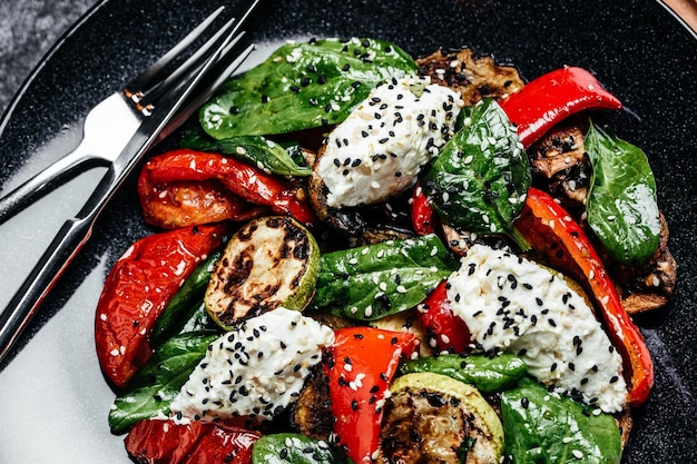 Delicious salad with roasted bell pepper zucchini eggplant with spinach leaves and feta cheese Restaurant menu dieting cookbook recipe top view