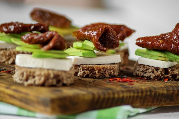 Delicious sandwiches with cheese avocado and dried tomatoes Concept for food healthy food