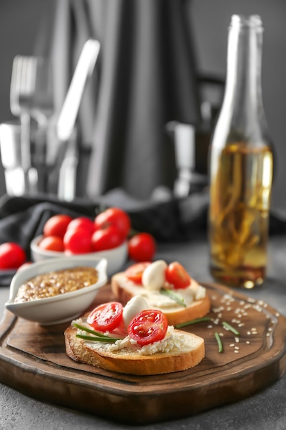 Delicious sandwiches with cherry tomato and mozzarella on wooden board