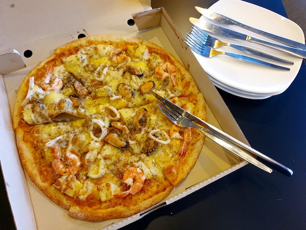 Delicious seafood cocktail pizza in the delivery box.