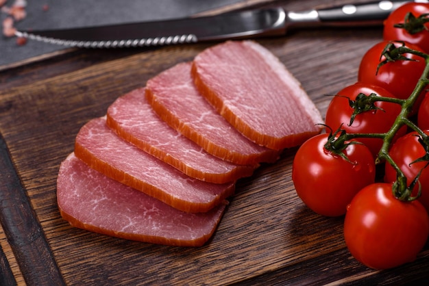 Delicious smoked meat cut with slices on a wooden cutting board