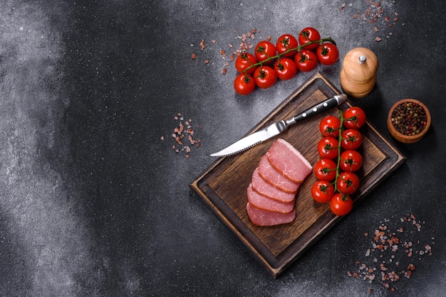 Delicious smoked meat cut with slices on a wooden cutting board