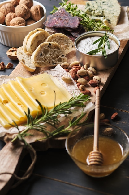 Delicious snacks. Several varieties of cheese, pretzels, nuts and sausage on an old wooden table.