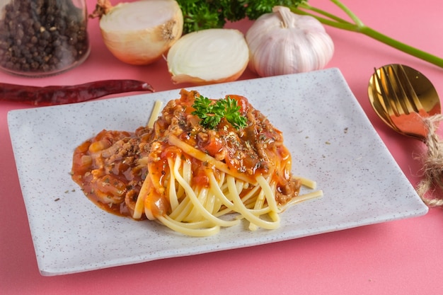 Delicious spaghetti with bolognese sauce served on a white square plate