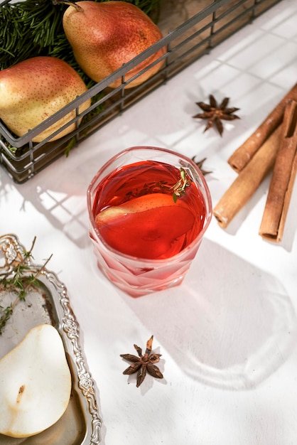 Delicious spicy hot mulled red wine with cinnamon star anise and slice pear served in a carafe and glass for a cold winter evening or festive Christmas beverage