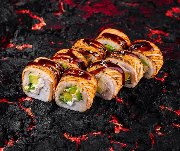 Photo delicious spicy sushi roll on charcoal background