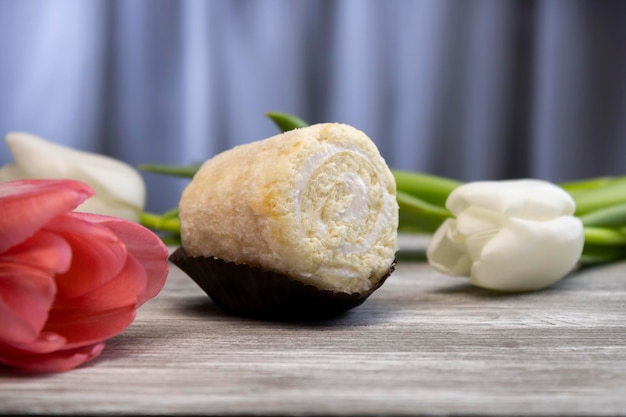 Delicious sponge cake with white and pink flowers in the background