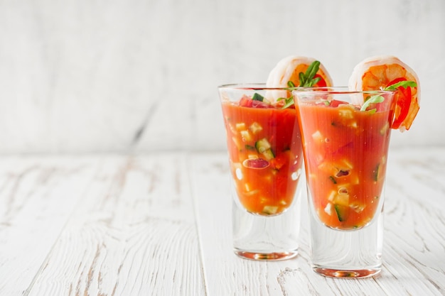 delicious summer gazpacho cocktail on a white wooden rustic background