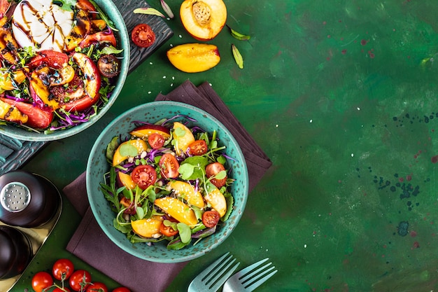 Delicious summer salad with burrata cheese and grilled peaches, arugula and microgreens. Healthy eating. copy space