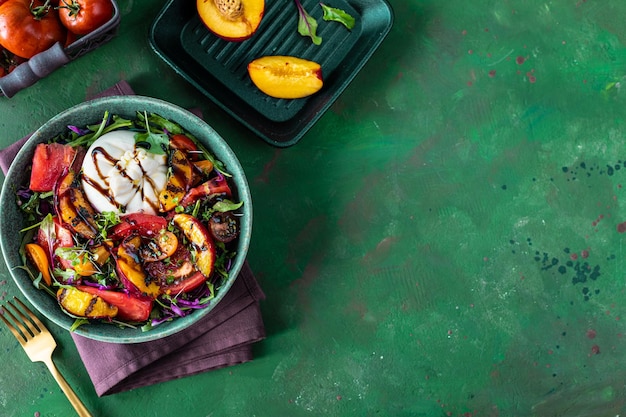 Delicious summer salad with burrata cheese and grilled peaches arugula and microgreens Healthy eating Flat lay top view