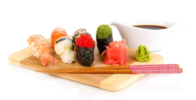 Delicious sushi served on wooden board isolated on white