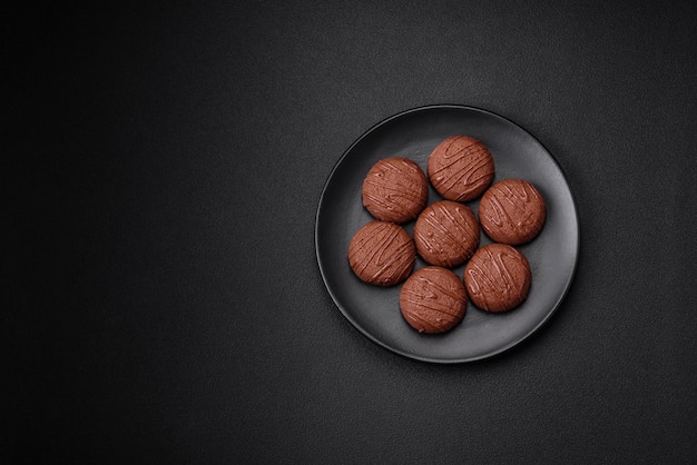 Delicious sweet chocolate cookies on a black ceramic plate