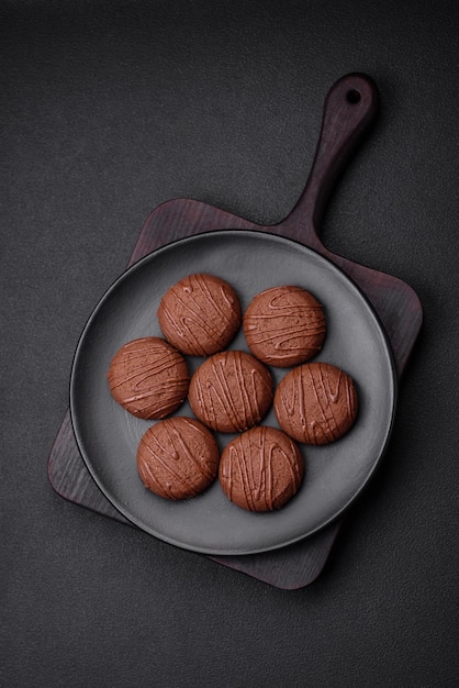 Delicious sweet chocolate cookies on a black ceramic plate