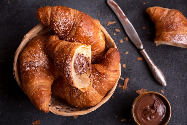 Delicious sweet croissant with chocolate on dark background