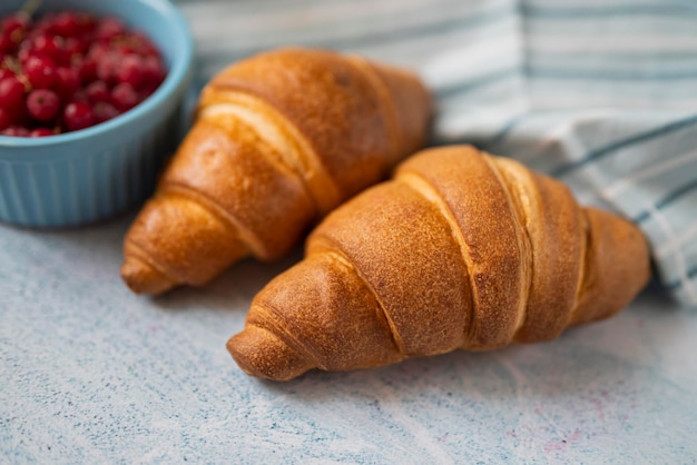 delicious sweet pastry croissant with red currant berry for breakfast