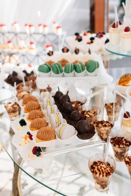 Delicious sweets on wedding candy buffet with desserts, cupcakes,tiramisu and cookies