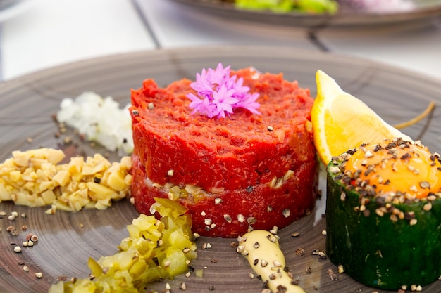 Delicious tartare from beef with egg on ceramic plate