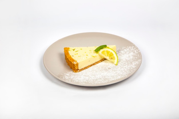 Delicious and tasty cheese cake slice with lemon and mint on plate in white background