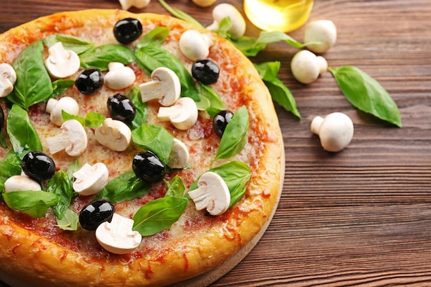 Delicious tasty pizza with ingredients on wooden table