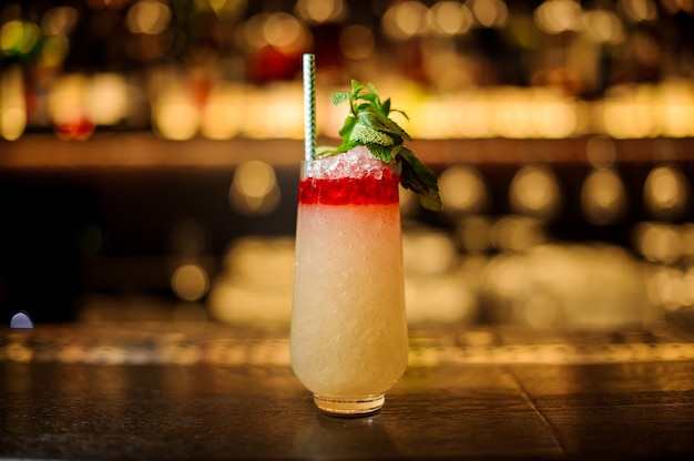 Delicious Trinidad Swizzle cocktail in the glass with tubule and mint leaves standing on the bar counter