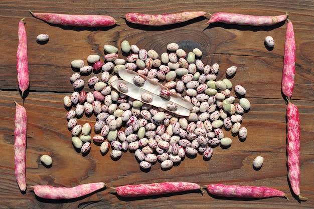 Delicious variegated raw common beans on an old wooden table