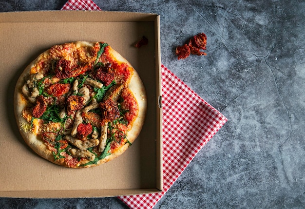 Delicious vegan pizza with tofu sundried tomatoes and arugula with additional text space