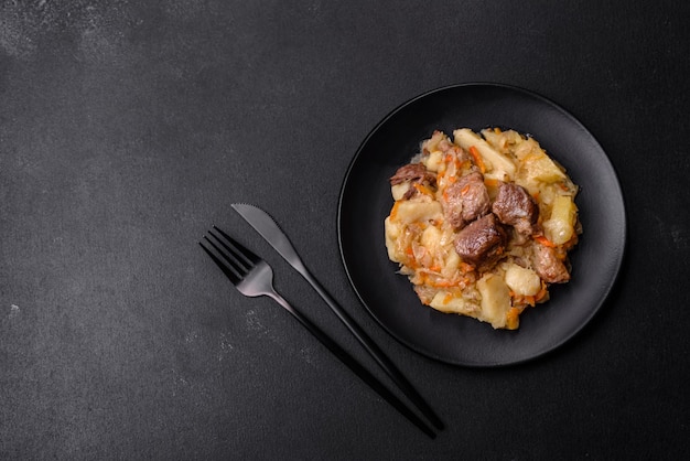 Delicious vegetable stew with beef potatoes carrots and cabbage in a black plate