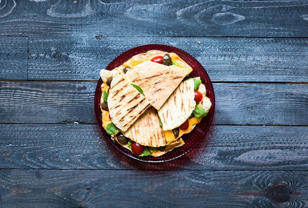 Delicious veggie quesadillas with tomatoes, olives, saÃ²ad and cheddar