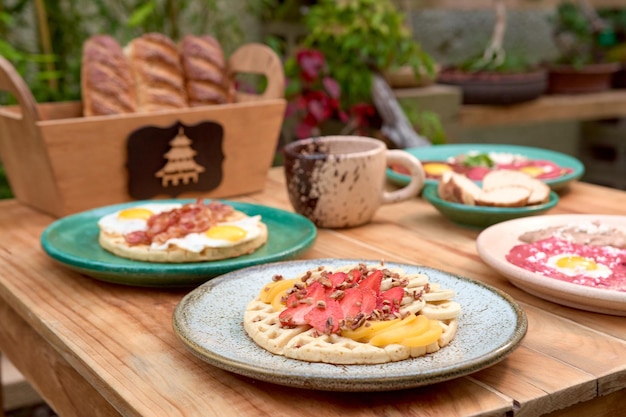 Delicious waffle with strawberry and peach on wooden table