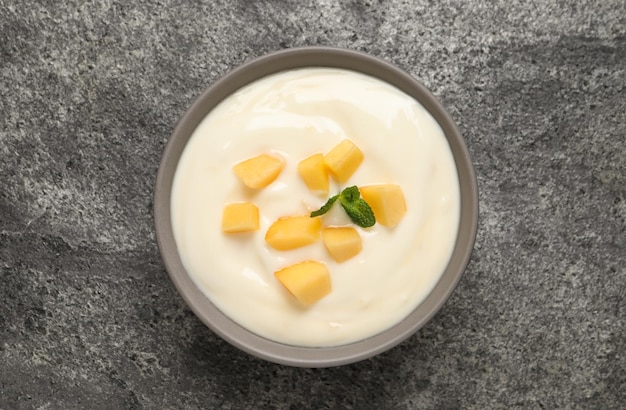 Delicious yogurt with fresh peach and mint on grey table top view