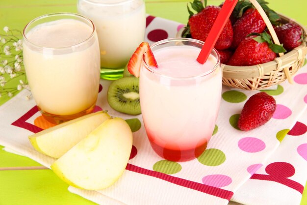 Delicious yogurts with fruits in glasses on wooden table closeup