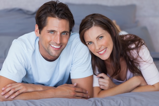 Delighted couple lying on bed