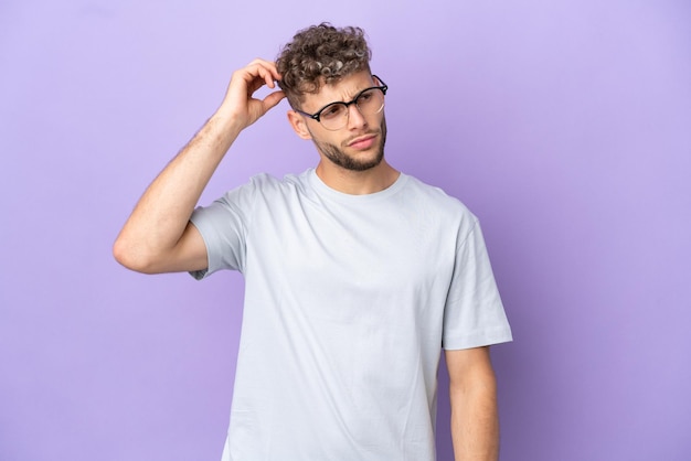 Delivery caucasian man isolated on purple background having doubts while scratching head