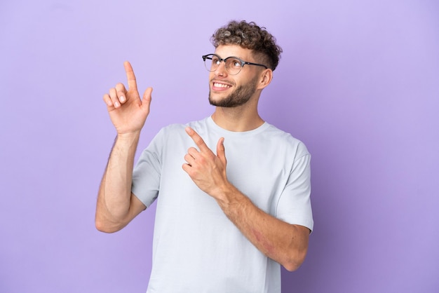 Delivery caucasian man isolated on purple background pointing with the index finger a great idea